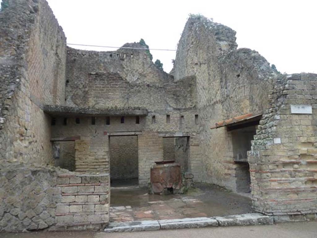 Ins. Orientalis II.5, Herculaneum. September 2015. Looking east towards entrance doorway.
The holes for the support beams and the part of the floor of the mezzanine can be seen against the east wall.
Above this, at the very top of the rear east wall are holes for support beams for an upper floor.